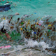 Una ola que lleva residuos plásticos en una playa en Koh Samui en el Golfo de Tailandia